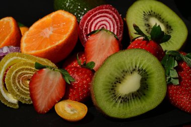 Siyah arka planda sarılmış jöleli meyve ve sebze çeşitleri