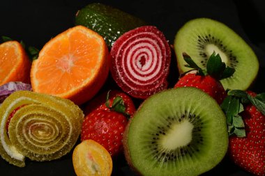 Siyah arka planda sarılmış jöleli meyve ve sebze çeşitleri