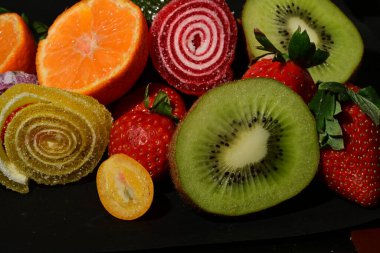 Siyah arka planda sarılmış jöleli meyve ve sebze çeşitleri