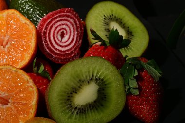 Siyah arka planda rulo jöleli meyve ve sebze çeşitleri.