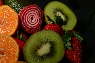 Siyah arka planda rulo jöleli meyve ve sebze çeşitleri.