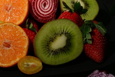 Siyah arka planda sarılmış jöleli meyve ve sebze çeşitleri