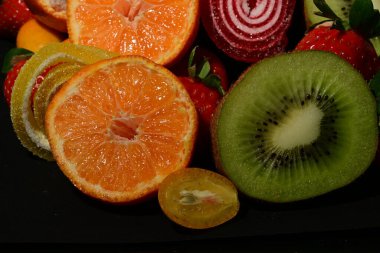 Siyah arka planda sarılmış jöleli meyve ve sebze çeşitleri