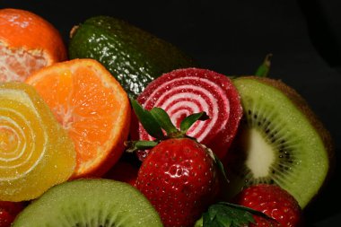 Siyah arka planda sarılmış jöleli meyve ve sebze çeşitleri