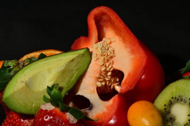 Siyah arka planda sarılmış jöleli meyve ve sebze grubu.