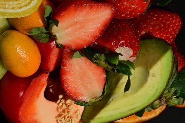 Siyah arka planda sarılmış jöleli meyve ve sebze grubu.