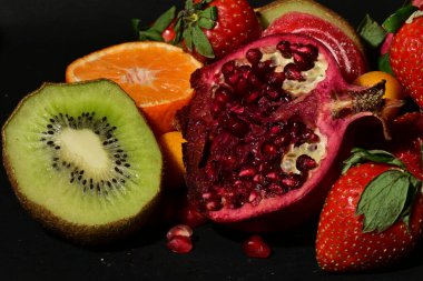 Siyah arka planda sarılmış jöleli bir grup meyve.