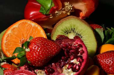 Siyah arka planda sarılmış jöleli meyve ve sebze grubu.