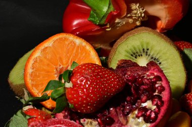 Siyah arka planda sarılmış jöleli meyve ve sebze grubu.