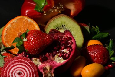 Siyah arka planda sarılmış jöleli meyve ve sebze grubu.