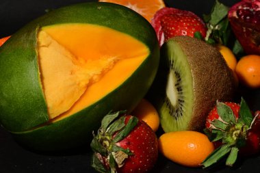 İkiye bölünmüş bir meyve kasesi ve koca bir meyve.