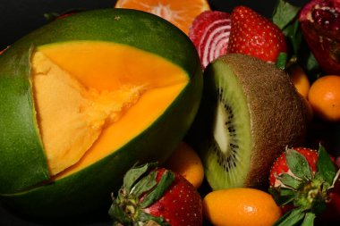 Bir meyve kasesinin yakın plan fotoğrafı, kivi, portakal, pipet.