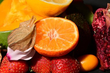 Portakallı ve çilekli bir kase meyve.