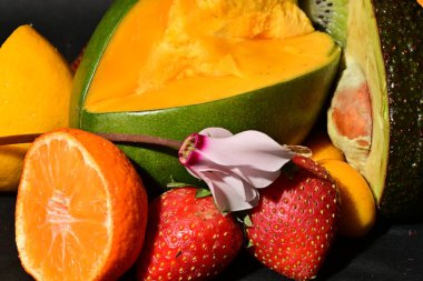 Siyah arka planda çiçekli çeşitli meyveler