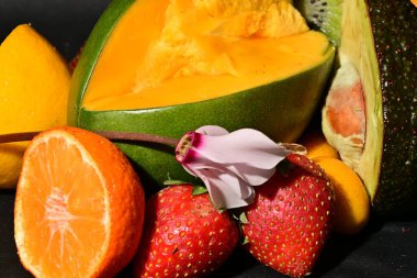 Siyah arka planda çiçekli çeşitli meyveler