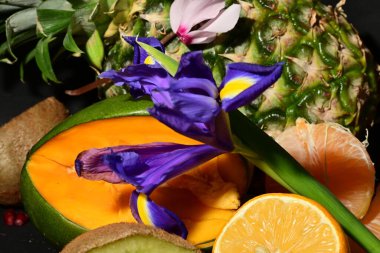 Masada bir tabak meyve ve çiçek.