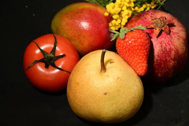 Siyah arka planda taze meyveler.