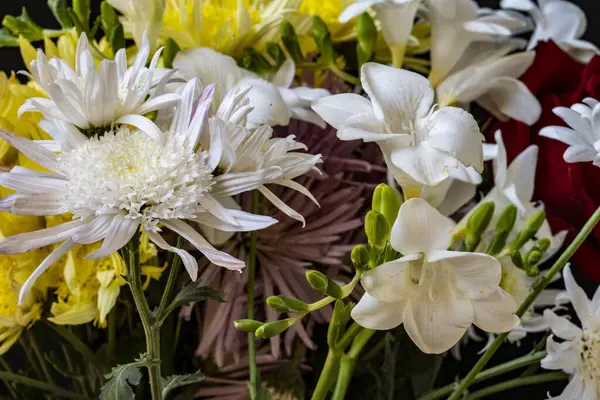 Karanlık bir arka planda güzel bir buket çiçek.