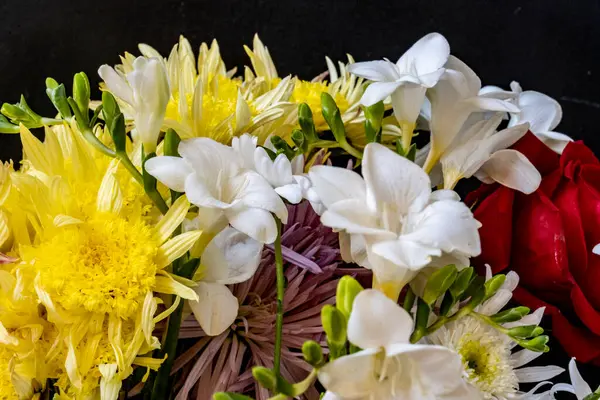 Karanlık bir arka planda güzel bir buket çiçek.