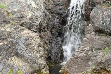 Dağlardaki güzel şelalenin manzarasını kapat.
