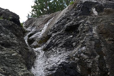 Dağlardaki güzel şelalenin manzarasını kapat.
