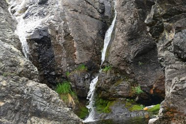 Dağlardaki güzel şelalenin manzarasını kapat.