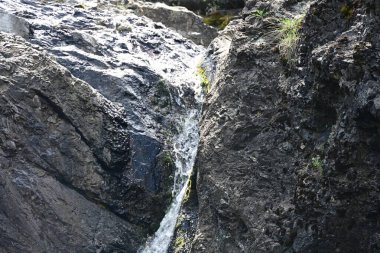 Dağlardaki güzel şelalenin manzarasını kapat.