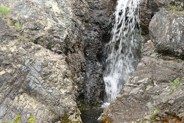 Dağlardaki güzel şelalenin manzarasını kapat.