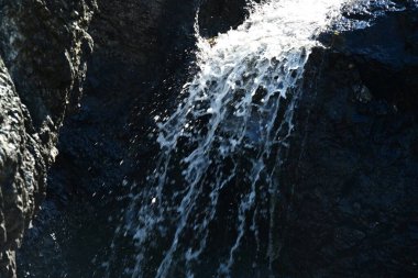 Dağlardaki güzel şelalenin manzarasını kapat.