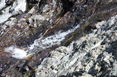 Taşlarla çerçevelenmiş zarif şelale ayrıntıları