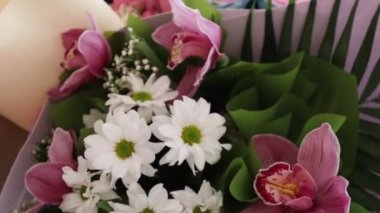 Beyaz papatya ve pembe orkideli bir buket.