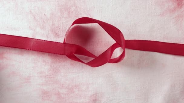 Renkli Arkaplana Kırmızı Kurdeleyle Bir Düğüm — Stok video