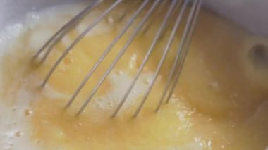 Sarı mısır unu ile paslanmaz çelik çırpma, polenta 'yı kaynayan suya karıştırıp yemek hazırlıyor.