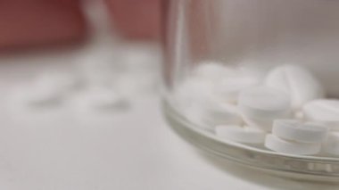 Masada beyaz ilaç hapları, kadın eli hap, ocak bakımı ve ilaç alıyor.