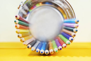 Çok renkli ahşap kalemler sarı arka plandaki masanın üzerinde, boş zamanların iş yeri.