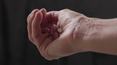  Siyah arka plan, ocak bakımı ve tıpta kadın elinde renkli ilaç hapları var.