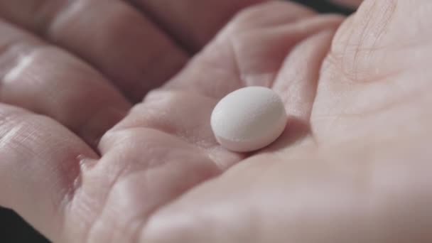 女性手中的白药丸有黑色底色 炉灶护理和药物 — 图库视频影像