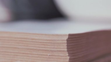 Birisi bir kitabın birkaç sayfasını okurken, boş zamanlarında ya da okurken çeviriyor.