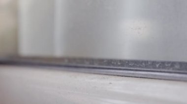 Sarı süngerle pencereyi temizlemek, ev işi.