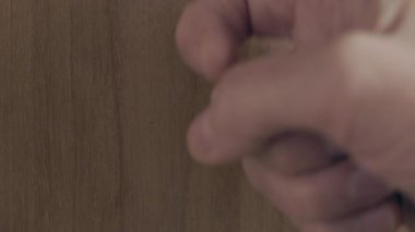 Kadın eli kahverengi ahşap kapıyı çalıyor, ziyaretçi veya misafir kapıda.