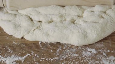 Hamuru pişirmeden önce düz yapmak için merdaneyle yuvarlamanın ayrıntıları 