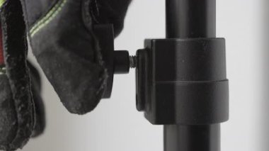 Elinizi iş eldiveniyle kapatın. Kelebeği sıkılaştırın. Siyah plastik kanatlı vida, iş yeri, evdeki bakım.