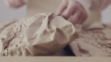 Teslimat kutusundan nakliye için kullanılan kahverengi koruyucu ambalaj kağıdını kaldır ve kahverengi hediye kutusu bul