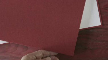 Açılış kitabı kırmızı ahşap masa üzerinde kırmızı sert kapak, eğitici konu