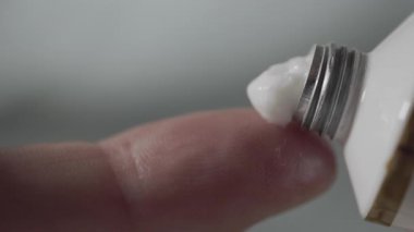 Beyaz bir tüpten sıkılmış beyaz nemlendirici krem, cilt estetiği.