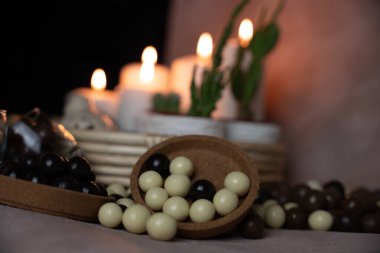 Çikolata ve karamel, yuvarlak ve lezzetli tatlı mum ışığının önünde duruyor.