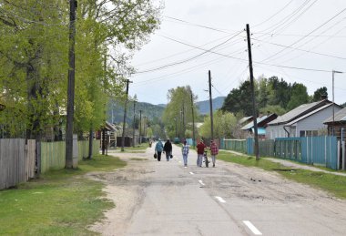  İnsanlar Rus köyü caddesinde yürüyorlar..