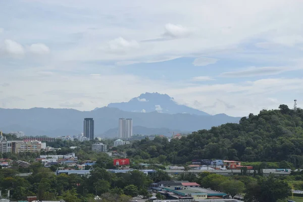 Kinabalu dağı ve bulutlu gökyüzü ile şehir manzarası.