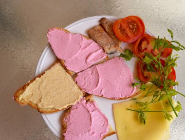 Bir tabakta sunulmuş, muzip ve taramasalata soslu sandviçler..