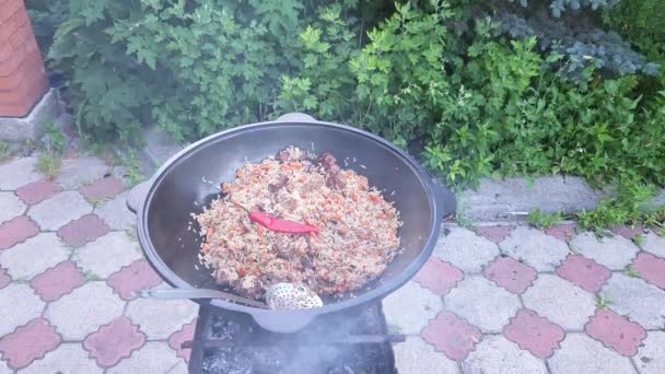 Gotowanie Uzbeckiego Pilafa Gotowy Pilaf Żeliwnym Kotle Stojącym Grillu Lekkim — Wideo stockowe